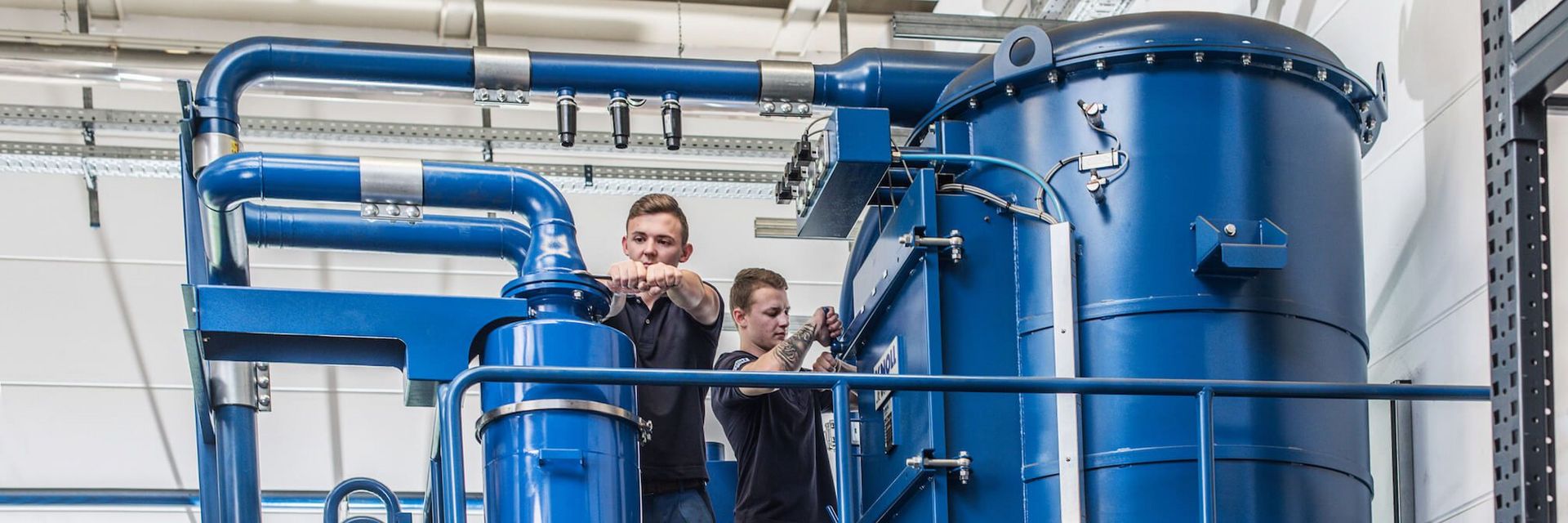 Mitarbeiter der KNOLL Maschinenbau GmbH montieren Absaugstation