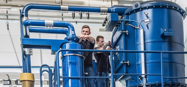 Mitarbeiter montieren Zentrale Sauganlage - KNOLL Maschinenbau GmbH