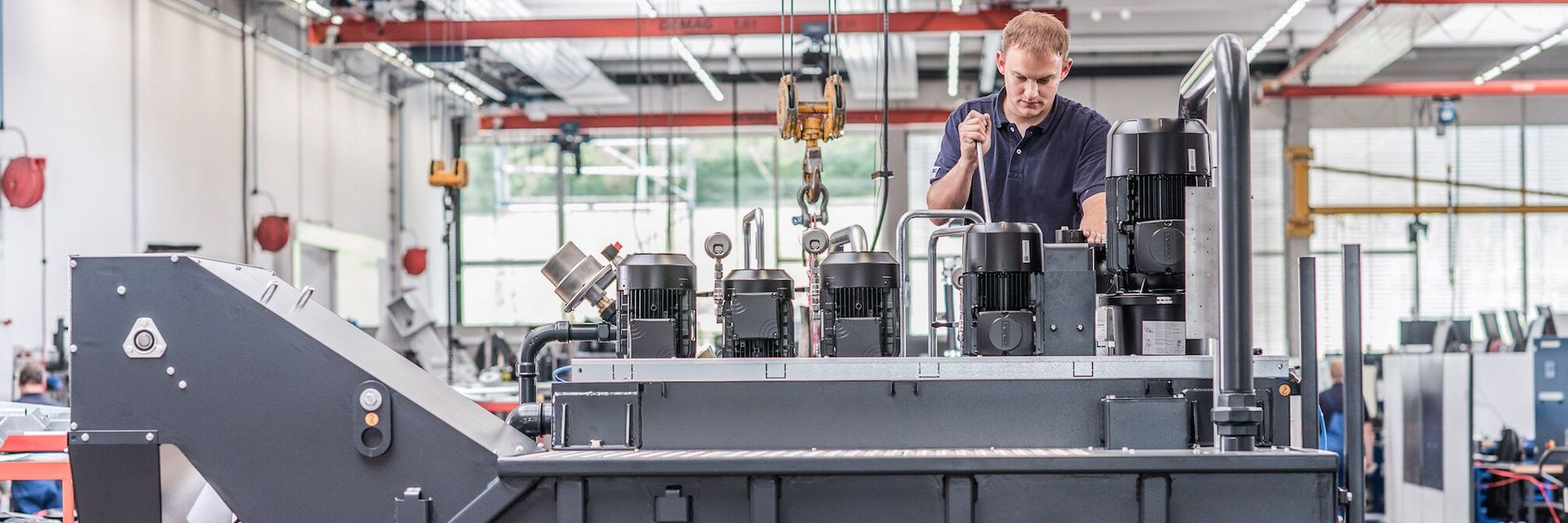 Mitarbeiter montiert System zur Späneaufbereitung - KNOLL Maschinenbau GmbH